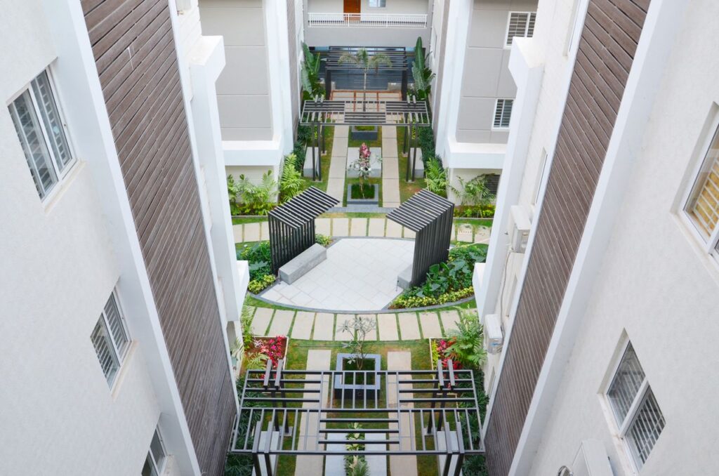 Aerial view of a stylish apartment courtyard with lush gardens in Hyderabad, India.